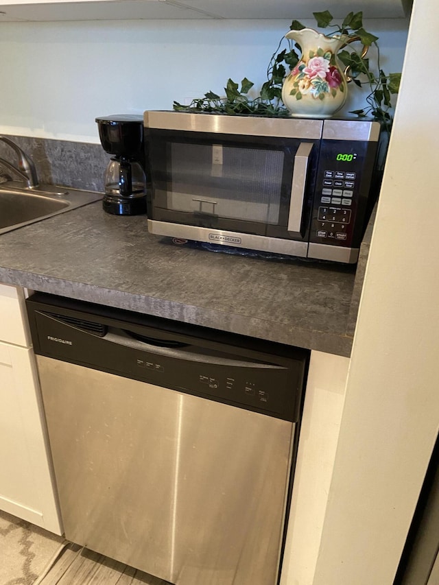 kitchen featuring appliances with stainless steel finishes, sink, and white cabinets