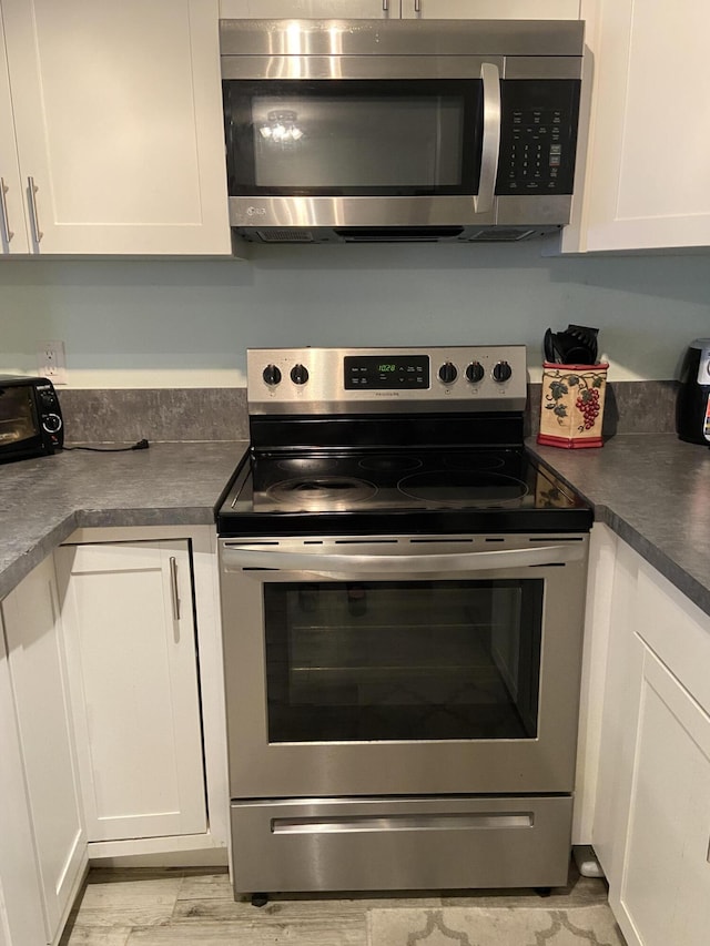 kitchen featuring white cabinetry and appliances with stainless steel finishes