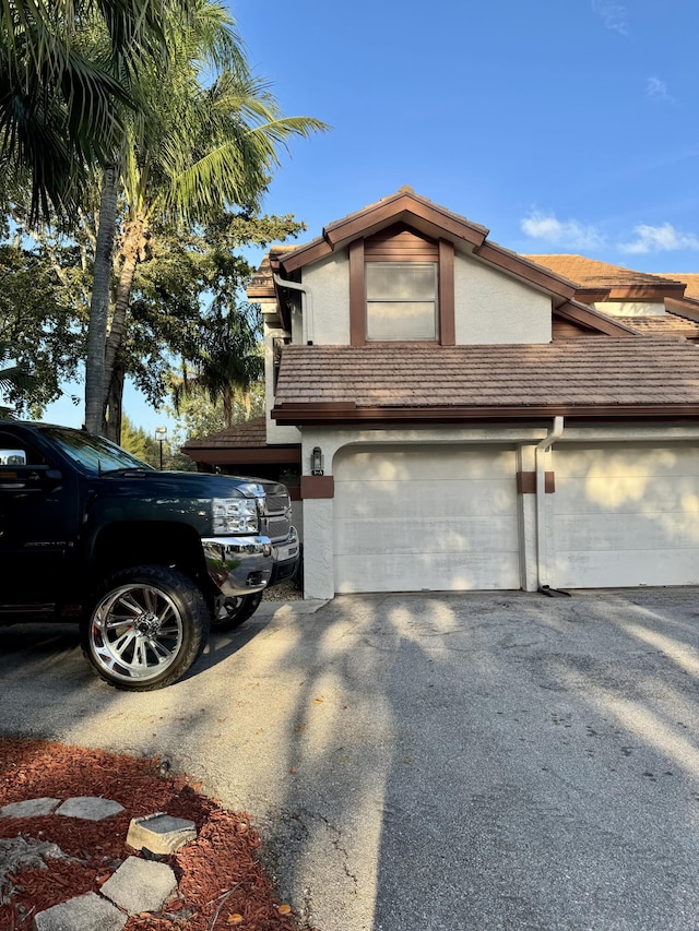 view of side of home featuring aphalt driveway and stucco siding