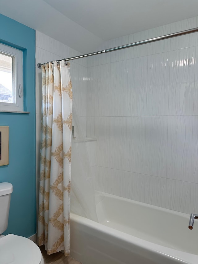 bathroom with shower / tub combo with curtain and toilet