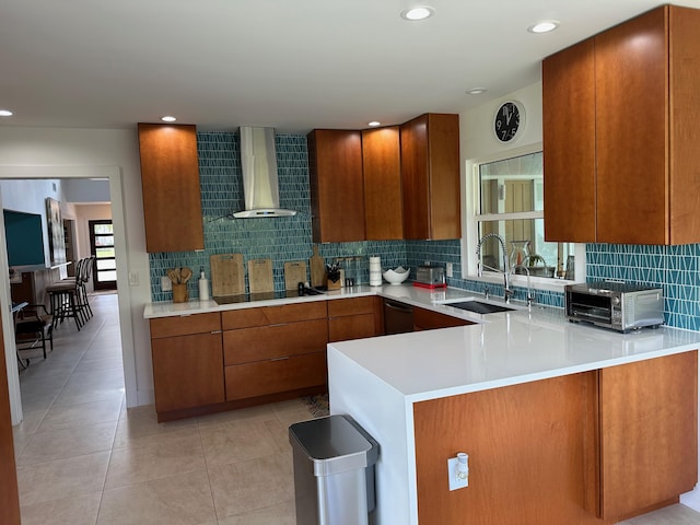 kitchen featuring wall chimney exhaust hood, kitchen peninsula, sink, and black appliances