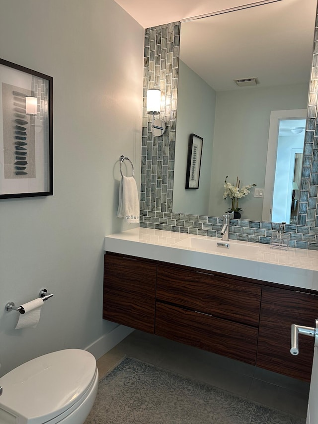 bathroom featuring vanity, decorative backsplash, tile patterned floors, and toilet