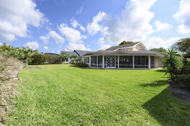 rear view of property with a sunroom and a lawn