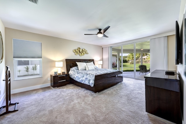 carpeted bedroom featuring ceiling fan, access to outside, and a wall of windows