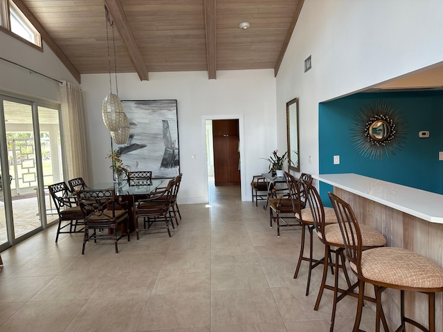 dining space featuring high vaulted ceiling, wooden ceiling, beamed ceiling, and bar area