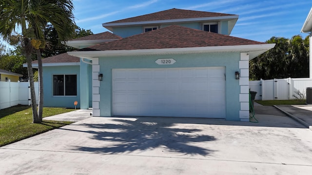 view of front of property featuring a garage and central AC