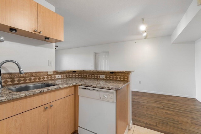 kitchen with sink, dark hardwood / wood-style floors, white dishwasher, kitchen peninsula, and light stone countertops