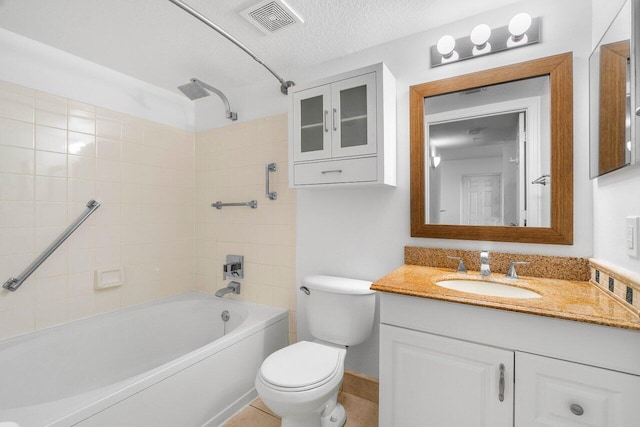 full bathroom with vanity, toilet, tiled shower / bath combo, and a textured ceiling