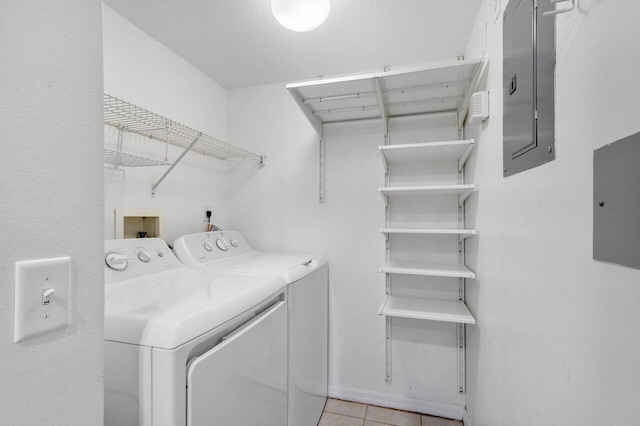 clothes washing area featuring light tile patterned floors, electric panel, and independent washer and dryer