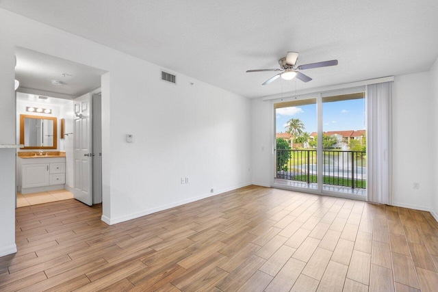 unfurnished room with sink, a textured ceiling, light hardwood / wood-style flooring, and ceiling fan