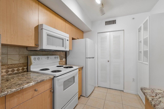 kitchen featuring light stone counters, white appliances, tasteful backsplash, and light tile patterned floors