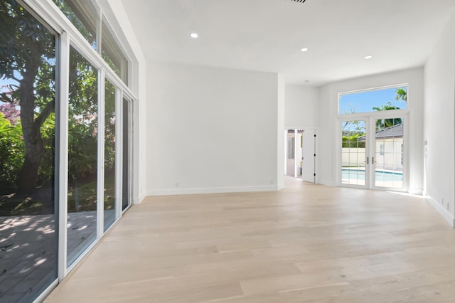 spare room featuring light wood-type flooring and french doors