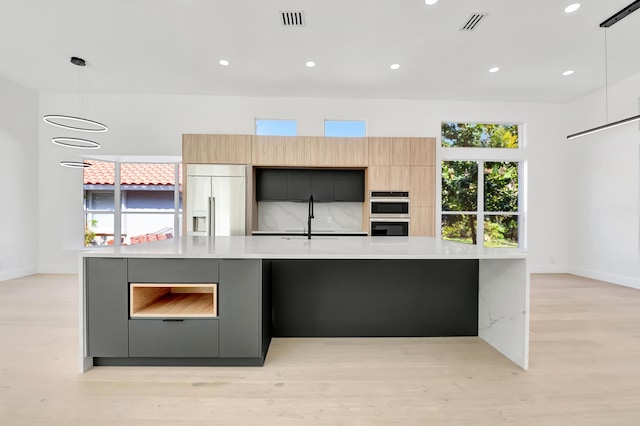 kitchen featuring pendant lighting, a spacious island, appliances with stainless steel finishes, and sink