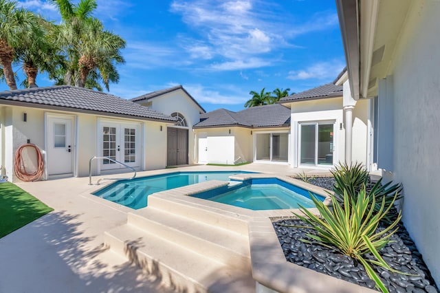 view of swimming pool with a patio, french doors, and an in ground hot tub