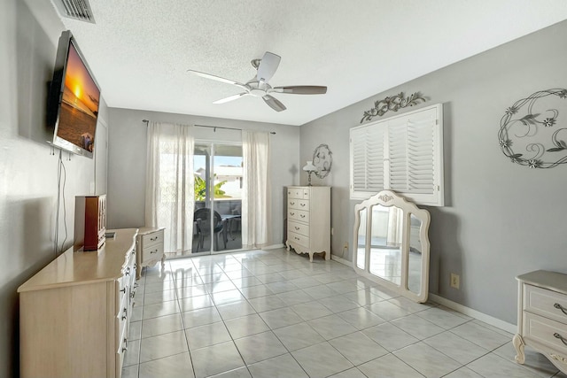 interior space with ceiling fan, access to outside, a textured ceiling, and light tile patterned floors