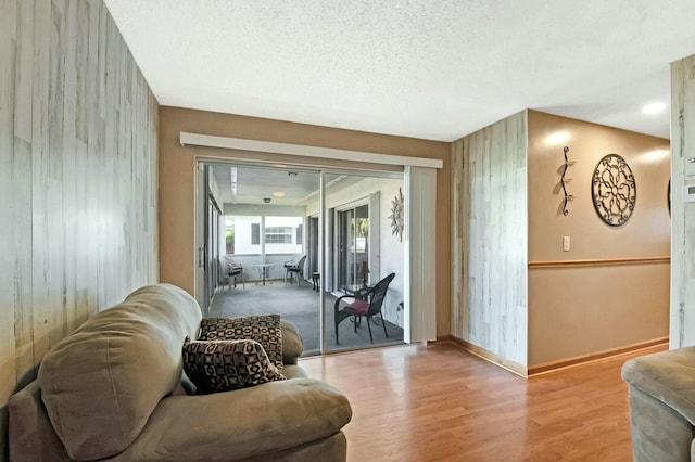 living room with a textured ceiling and light wood-type flooring