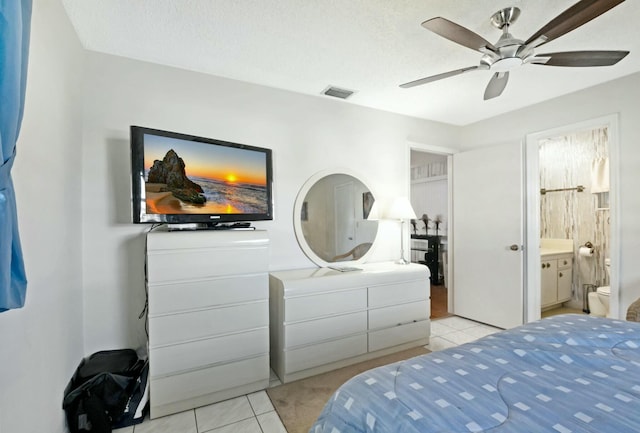 tiled bedroom with ceiling fan, a textured ceiling, and ensuite bathroom