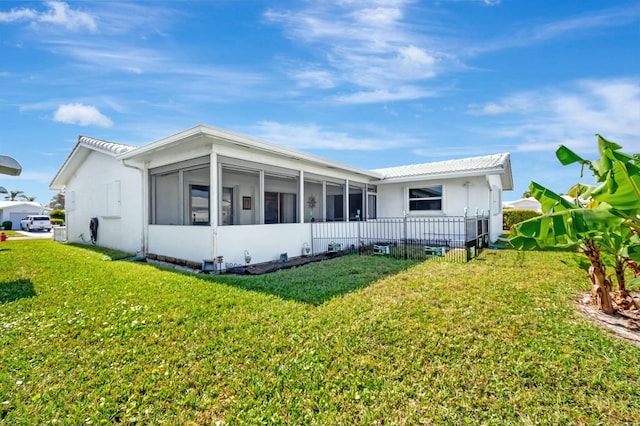 back of house featuring a yard and a sunroom