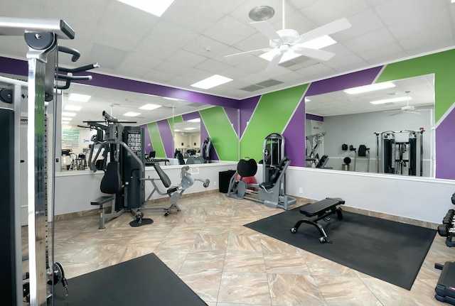 exercise room with a paneled ceiling and ceiling fan