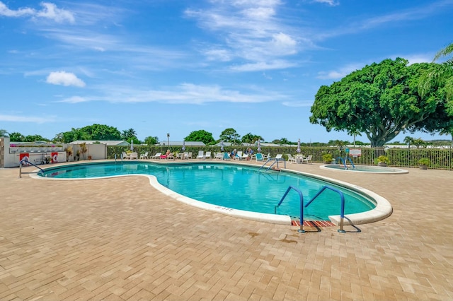 view of pool featuring a hot tub and a patio