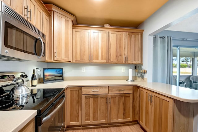 kitchen with electric stove, kitchen peninsula, and light hardwood / wood-style flooring