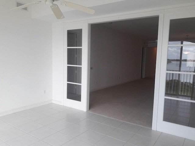 spare room with ceiling fan and light tile patterned flooring