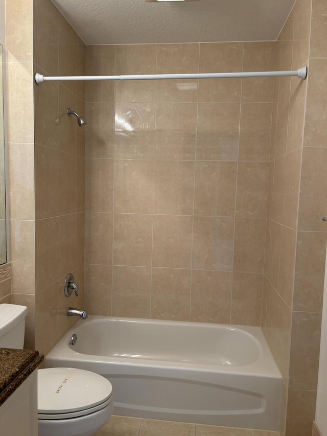 full bathroom featuring tile patterned floors, toilet, tiled shower / bath, a textured ceiling, and vanity