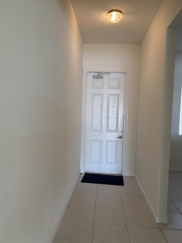 entryway with light tile patterned floors and a textured ceiling