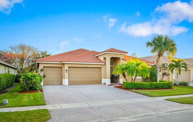 mediterranean / spanish-style house featuring a garage and a front lawn