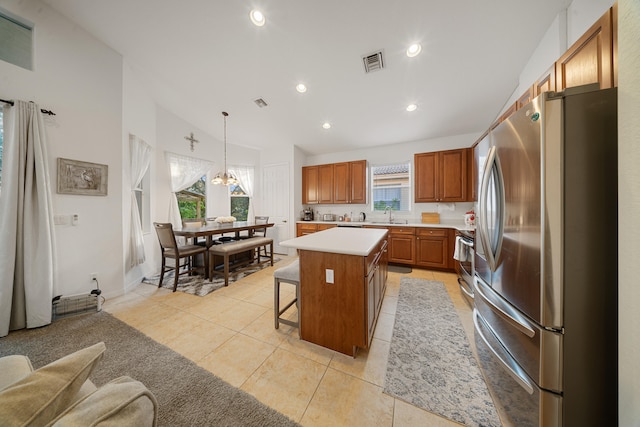 kitchen featuring light tile patterned floors, a breakfast bar, stainless steel appliances, a kitchen island, and decorative light fixtures