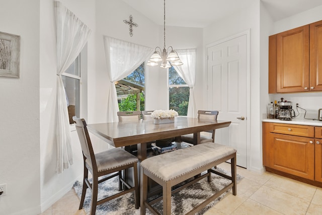 tiled dining space with an inviting chandelier and lofted ceiling