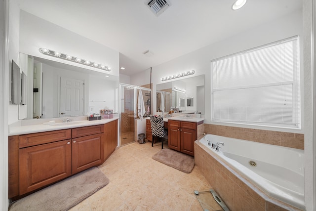 bathroom with vanity and shower with separate bathtub