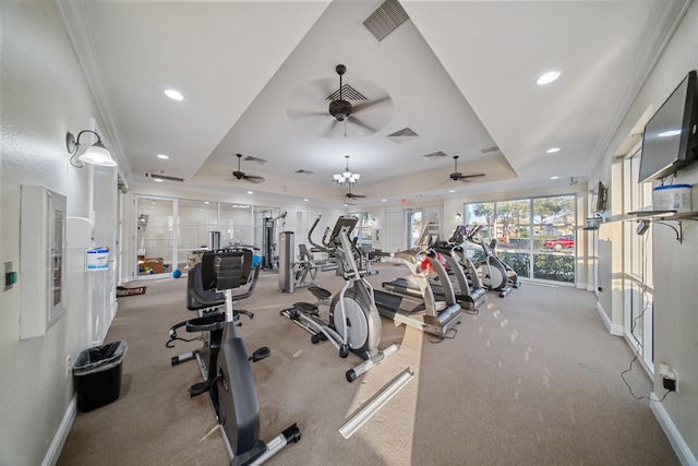 workout area with a raised ceiling, crown molding, and ceiling fan