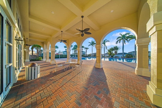 view of patio featuring a water view, a community pool, and ceiling fan