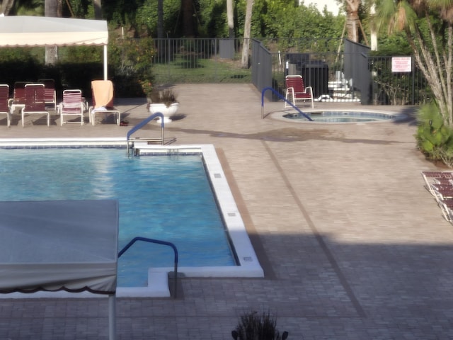 view of swimming pool with a community hot tub and a patio area