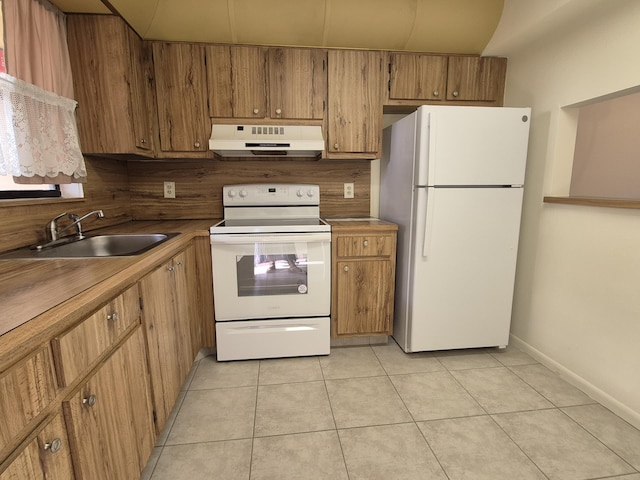 kitchen featuring sink, white appliances, and light tile patterned floors