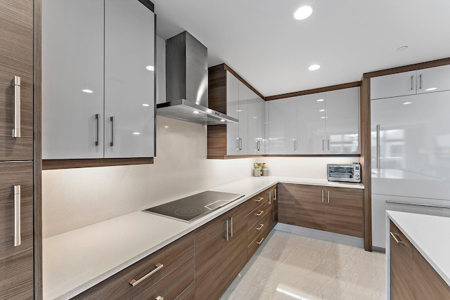 kitchen featuring built in refrigerator, white cabinets, black electric cooktop, and wall chimney exhaust hood