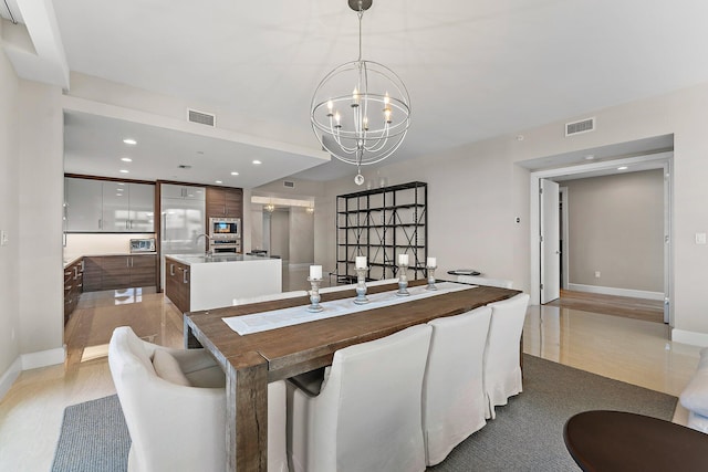 dining room with sink and a chandelier