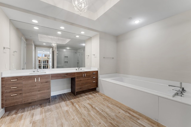 bathroom featuring hardwood / wood-style flooring, vanity, and plus walk in shower