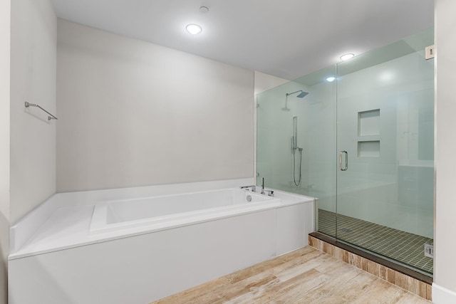 bathroom with shower with separate bathtub and hardwood / wood-style floors