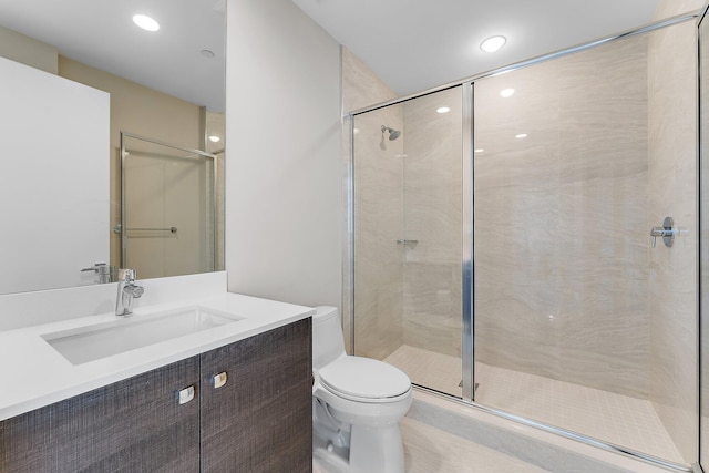 bathroom with vanity, toilet, and a shower with shower door