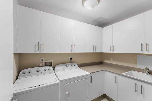 washroom with cabinets, sink, and washer and clothes dryer