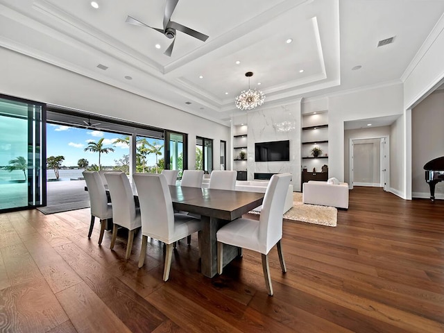 dining room featuring ceiling fan with notable chandelier, ornamental molding, built in features, and dark hardwood / wood-style floors