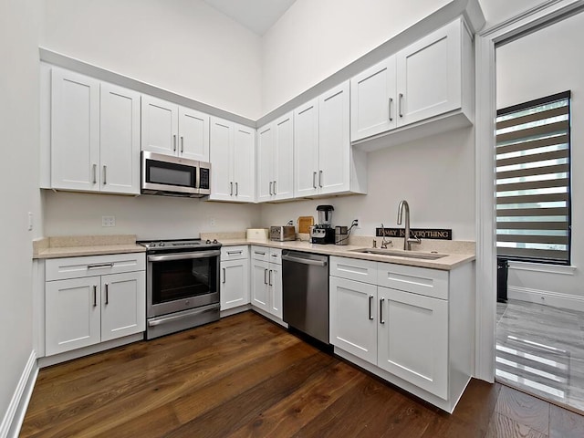 kitchen featuring white cabinetry, appliances with stainless steel finishes, sink, and dark hardwood / wood-style flooring