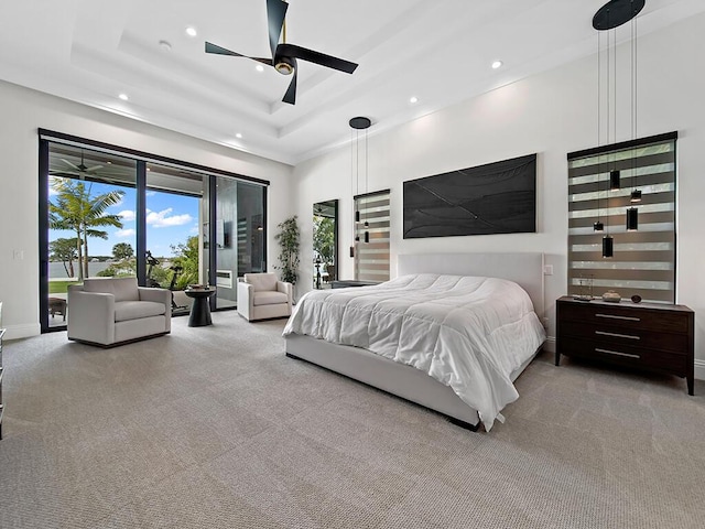 bedroom with ceiling fan, light colored carpet, a raised ceiling, and access to outside