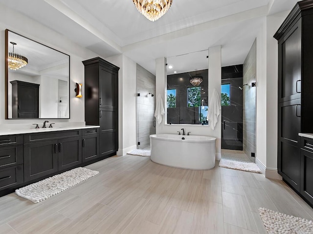 bathroom featuring vanity, a notable chandelier, and separate shower and tub