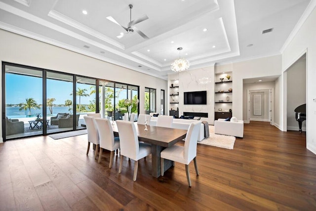 81 S River Rd, Stuart, FL 34996 - dining room featuring visible vents, built in shelves, crown molding, ceiling fan with notable chandelier, and hardwood / wood-style floors