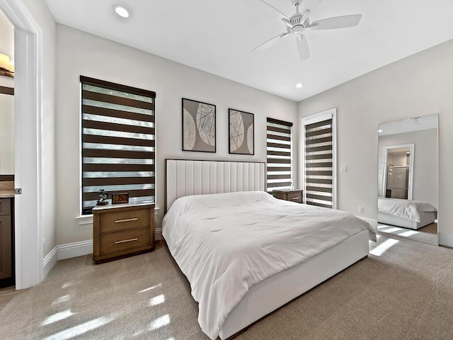 carpeted bedroom with ceiling fan and ensuite bath