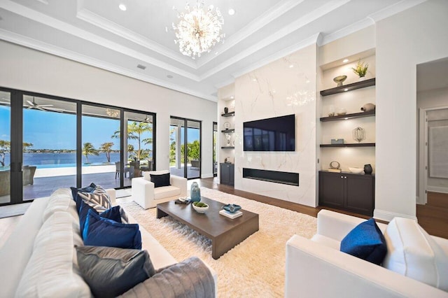 81 S River Rd, Stuart, FL 34996 - living area with built in features, a tray ceiling, and wood finished floors