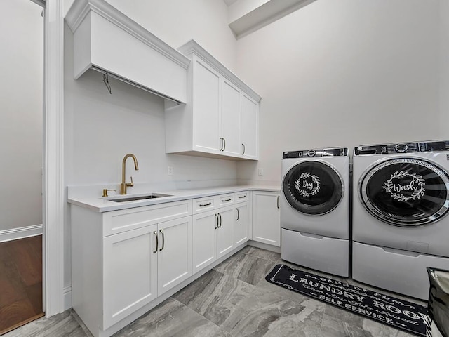 laundry room featuring separate washer and dryer, sink, and cabinets